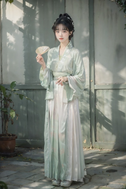  A young woman around twenty years old, dressed in Song-style Hanfu, wears a fresh green short shan that exudes a sense of purity. The red songmo complements her green and white gradient pleated skirt, blending the classical with the contemporary. Standing in an antique courtyard, sunlight filters through the leaves, casting dappled shadows on her, adding a serene and elegant aura. She holds a folding fan in her hand, the landscape painting on its surface harmonizing with her surroundings, as if she is a living classical painting., hanfu,song style outfits, 1girl,汉服