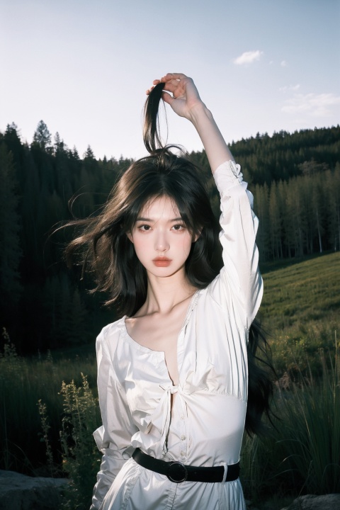 A girl, her hair flowing in the wind, stands on a rocky outcrop in the forest, the trees stretching out behind her. The scene is captured using a Fujifilm X-T3 with a 16-55mm f/2.8 lens, the image having a sharp and clear focus. The photograph has a sense of drama and tension, inspired by the works of Helmut Newton.