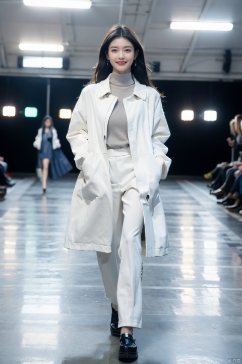  The image shows a model walking down a runway in a bright blue coat and white trousers. The runway is set in a spacious, well-lit environment with multiple spotlights. The model exudes confidence and grace, with a slight smile on her face and her hands held by her sides. It appears to be a highly successful and memorable runway show.