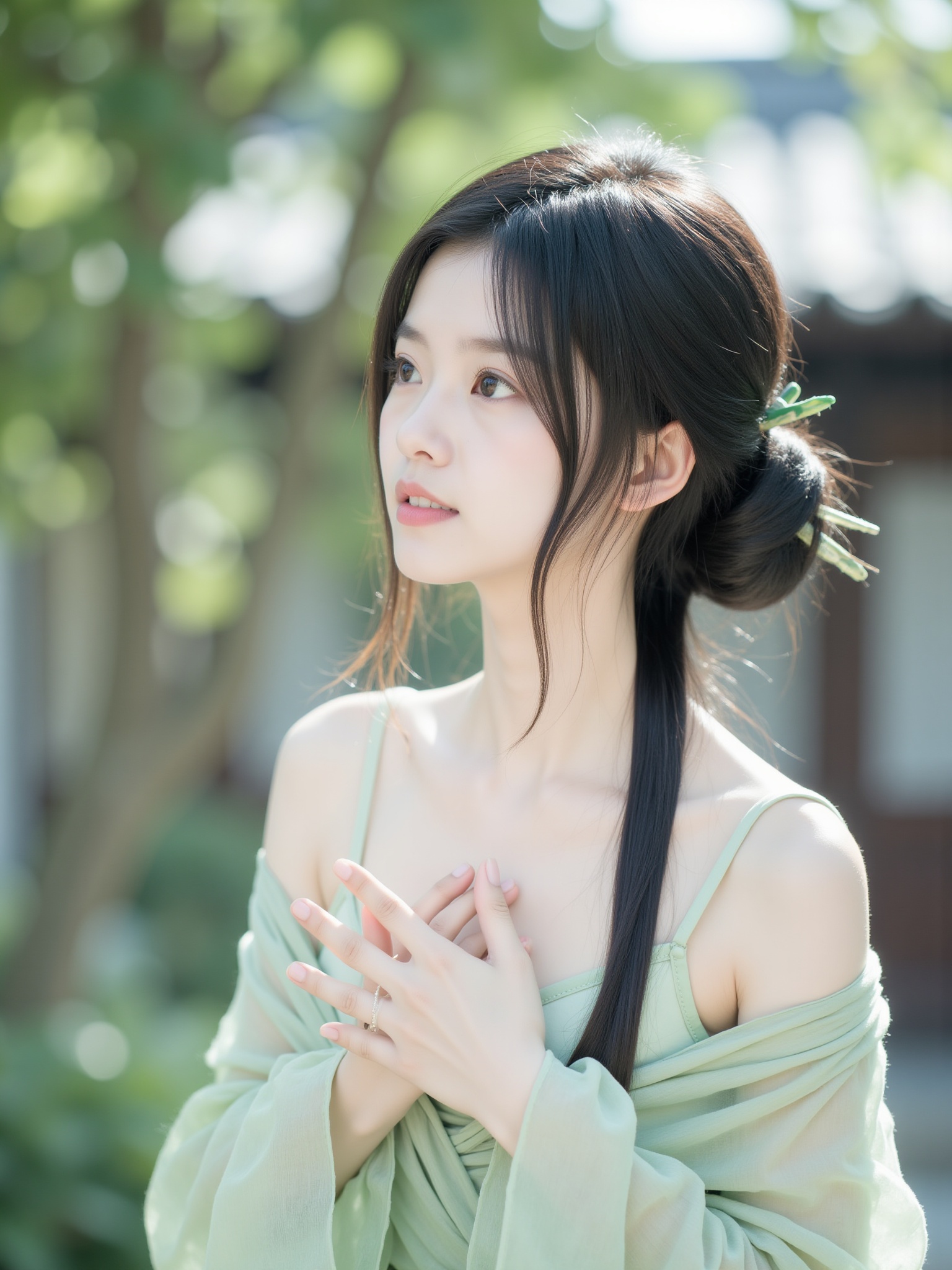 The photograph captures a young woman in a serene, outdoor setting, bathed in soft, natural light. She is of East Asian descent, with smooth, fair skin and delicate features, including large, almond-shaped eyes and a small, delicate nose. Her long, straight black hair is styled in an intricate updo, with loose strands framing her face, and adorned with small green hairpins. She wears a light green, off-the-shoulder top, which is slightly sheer, revealing her collarbone and shoulders, and a sheer, light green wrap that drapes elegantly around her, adding a touch of softness and elegance to her attire. Her expression is contemplative, with a slight smile, and her hands are gently clasped together in front of her chest, suggesting a sense of calm and introspection. The background features lush, green foliage and a blurred, wooden structure, possibly a traditional house, indicating a tranquil, possibly rural setting. The overall mood of the photograph is one of serenity and timeless beauty, with a focus on the woman's ethereal, ethereal presence and the harmonious blend of nature and human form. <lora:小红书顶流嫩妹脸模FLUX:1>