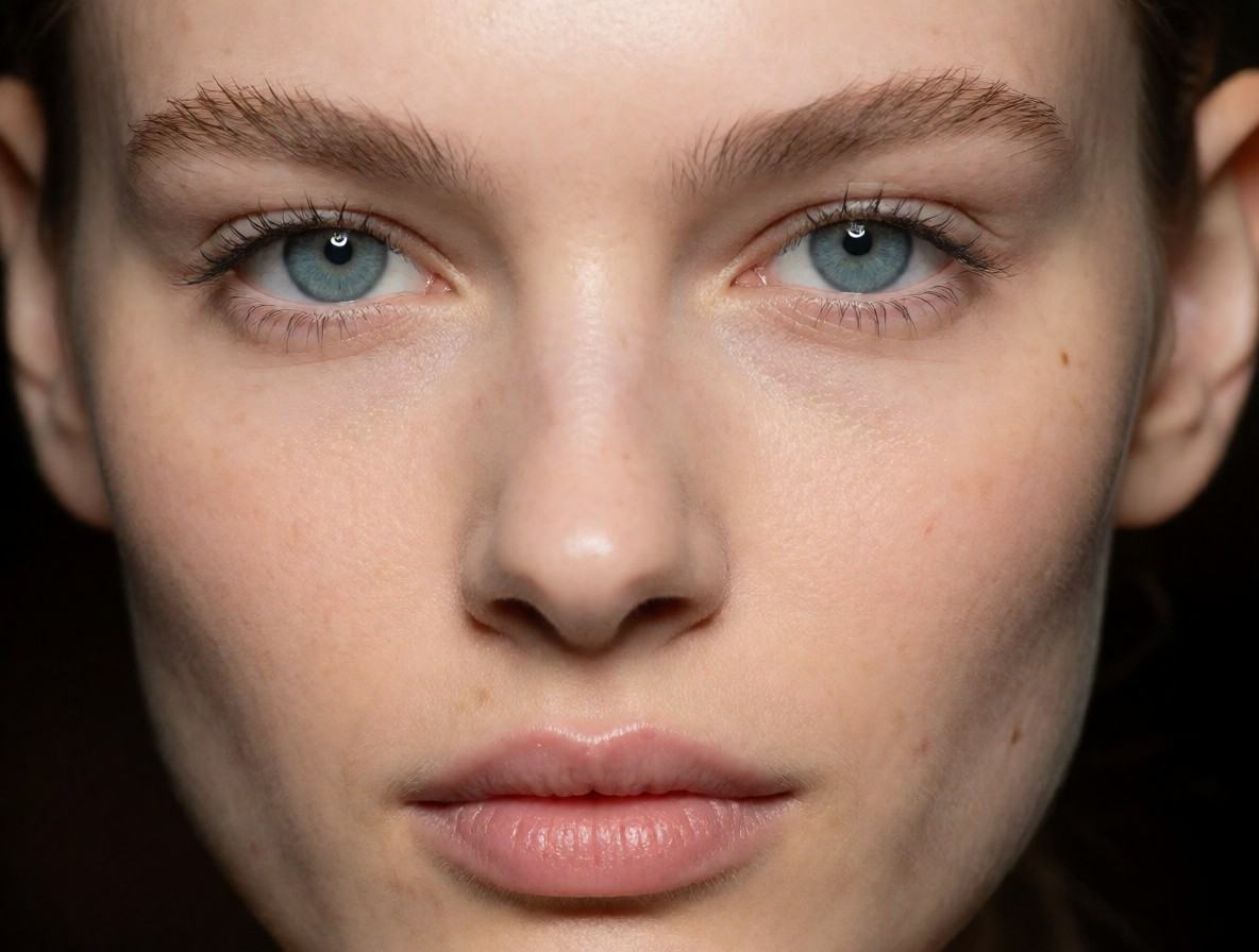 Close-up portrait of a female model's face,  focusing on the eyes. Blue eyes. Capture fine skin textures,  pores on Tensor...
