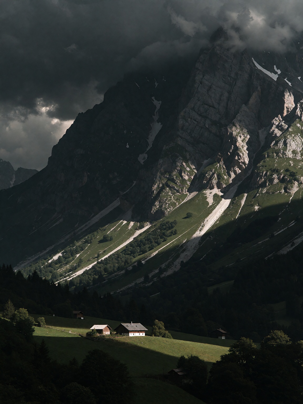 massive dark mountain under heavy storm clouds,  dramatic shaft of sunlight striking a steep green hillside,  tiny farmhou...