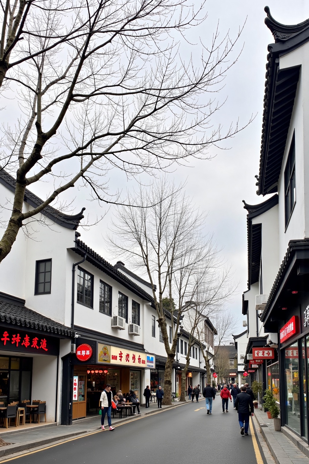 landscapejam, zssyj,landscapejam,zssyj,The image depicts a street scene in a traditional Chinese town. The architecture features white walls with black trim,characteristic of classic Chinese buildings. There are several shops along the street,including a restaurant with a sign in red Chinese characters,a fast-food restaurant with a sign in English,and a store with a sign in Chinese characters. People are walking on the sidewalk,and there are trees with bare branches,suggesting it might be late autumn or winter. The sky is overcast,and the overall atmosphere is calm and typical of a small town in China.,