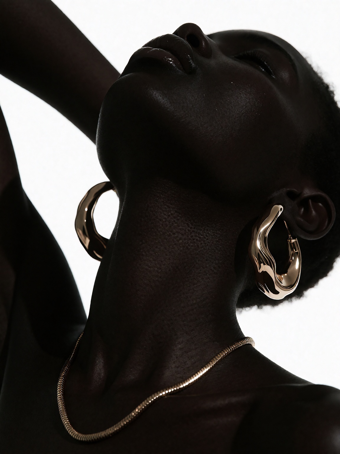 A high-contrast portrait of a dark-skinned figure tilting their head back against a pure white background. Deep shadows an...