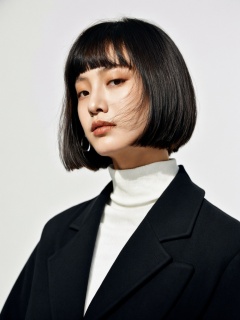 young asian woman, mid-length dark hair, bob haircut, subtle makeup, natural look, pensive expression, side glance, white turtleneck, oversized black jacket, simple silver hoop earring,best quality,masterpiece,