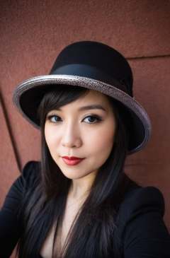 A woman wearing a hat poses for a picture, in the style of oshare kei, black, wide lens, shiny/ glossy, solapunk, dark silver, rim light