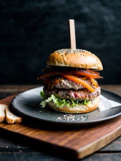 appetizing gourmet burger, sesame seed bun glistening hint golden brown toast, sits rustic slate plate dark backdrop, illuminated evoke warm, somber atmosphere, burger skillfully layered succulent,,best quality,masterpiece,