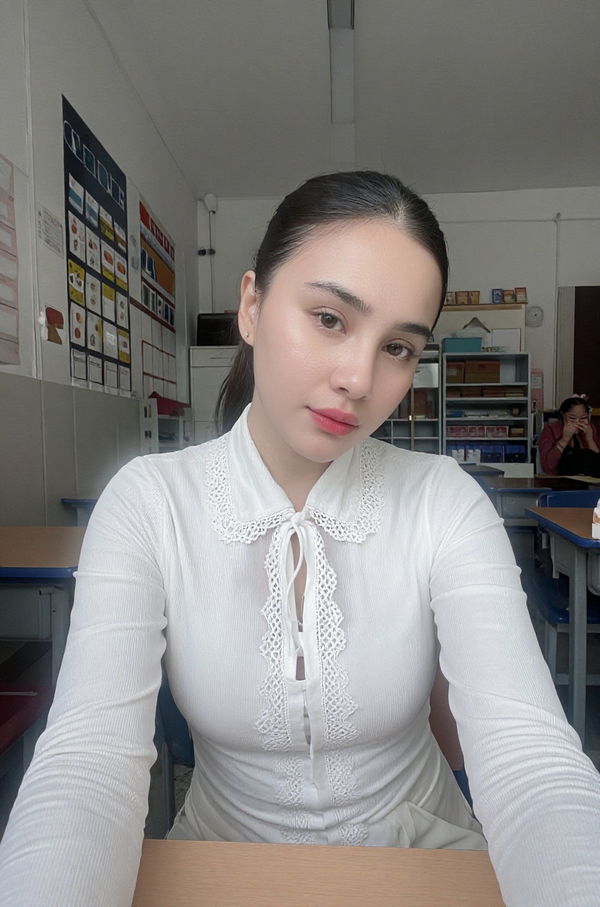 a photograph captures a woman sitting at a desk inside what appears to be a classroom setting with shelves,  organizers,...