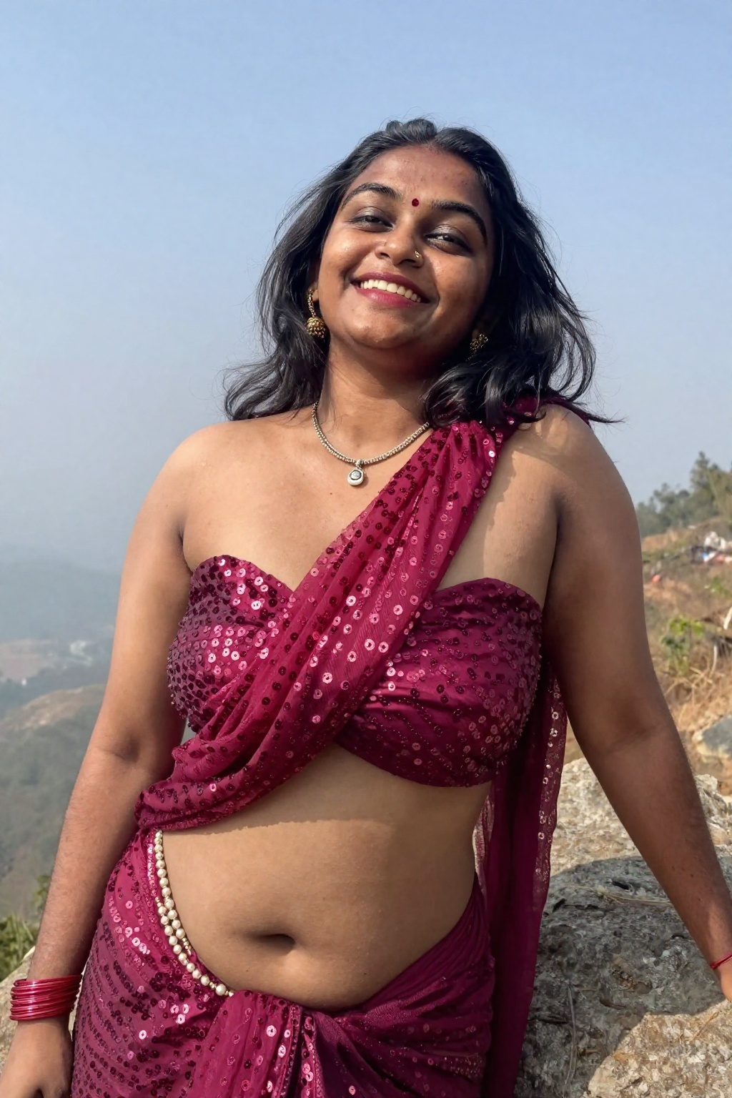 Photograph of a smiling Indian woman with medium-dark skin and black shoulder-length hair,  striking worm's eye shot from...