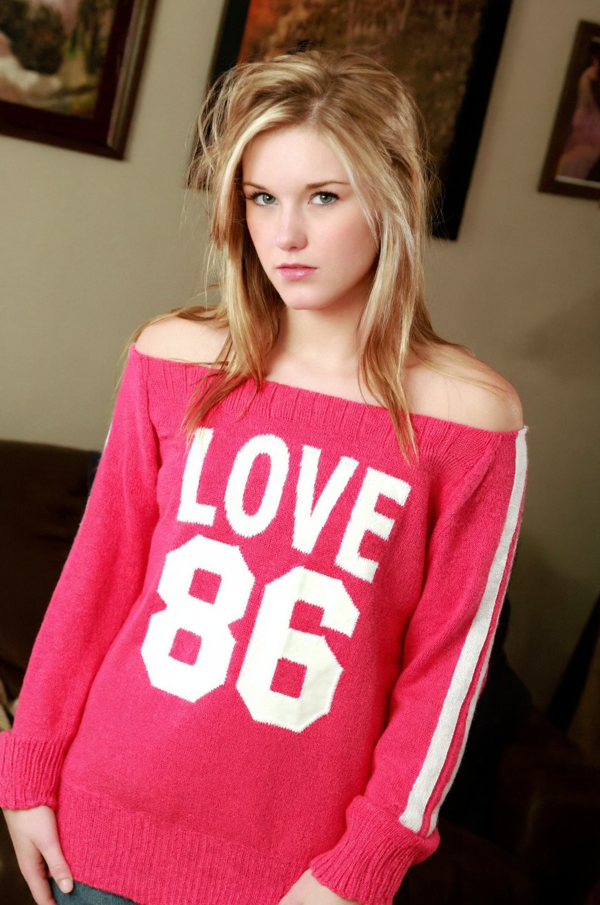 woJ3w3l a young woman with BLONDE,  shoulder-length hair styled loosely around her face. She is wearing a casual,  off-the...