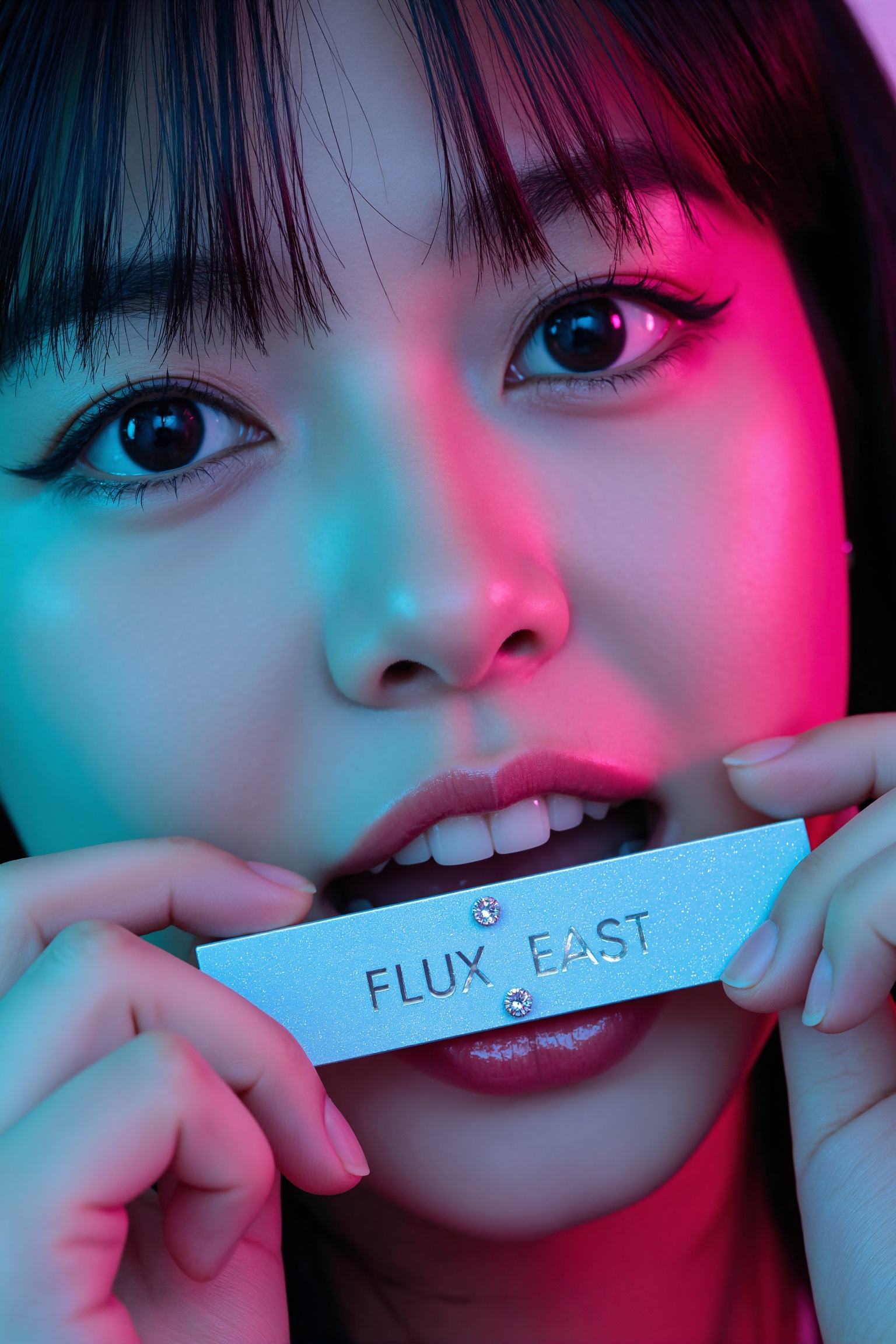 Poster: close-up of a beautiful Japanese woman’s face—black hair,  magenta accents—biting a turquoise nameplate that reads...