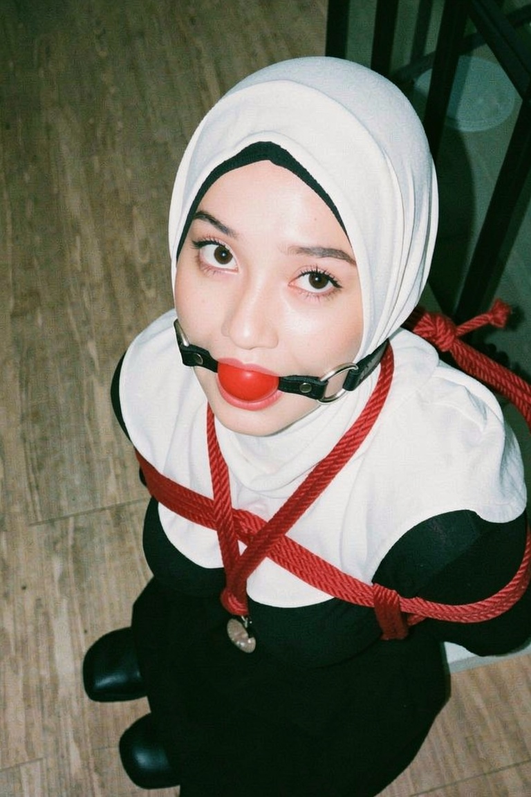 Arms behind back ropedwith smallest red roped boxtied style Make her mouth ballgagged with straps over her neck (image ref...
