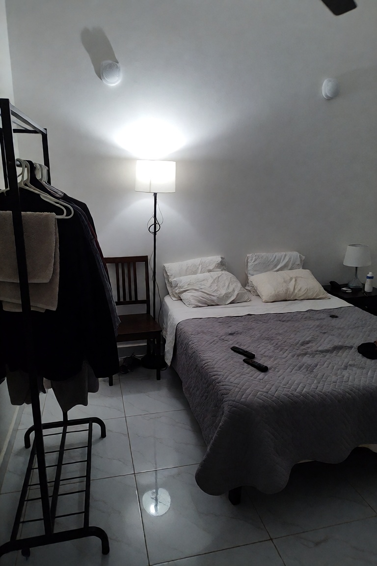 A medium-shot,  eye-level indoor photograph captures a simple,  minimalist bedroom with a neutral on Tensor.Art