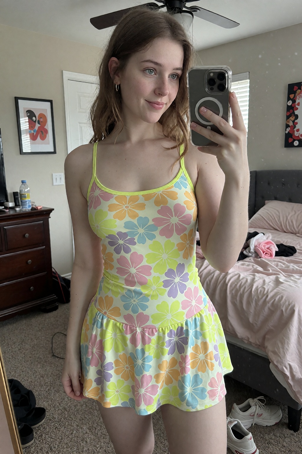 a full body mirror selfie of a woman in her early 20s in her contemporary bedroom with decor and clutter. She is wearing a...