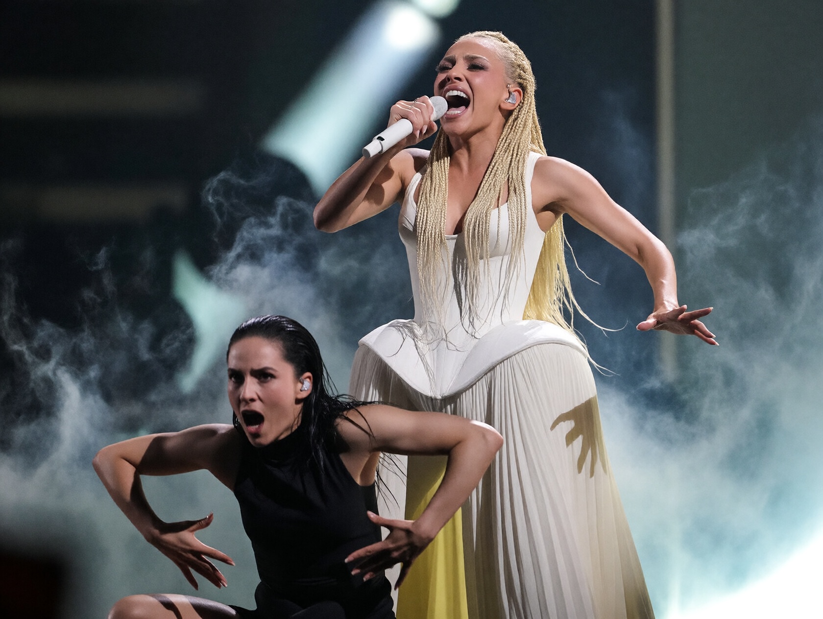 {"high_level_description":"A high-octane concert photograph of a pop star with blonde braids performing with intense emoti...