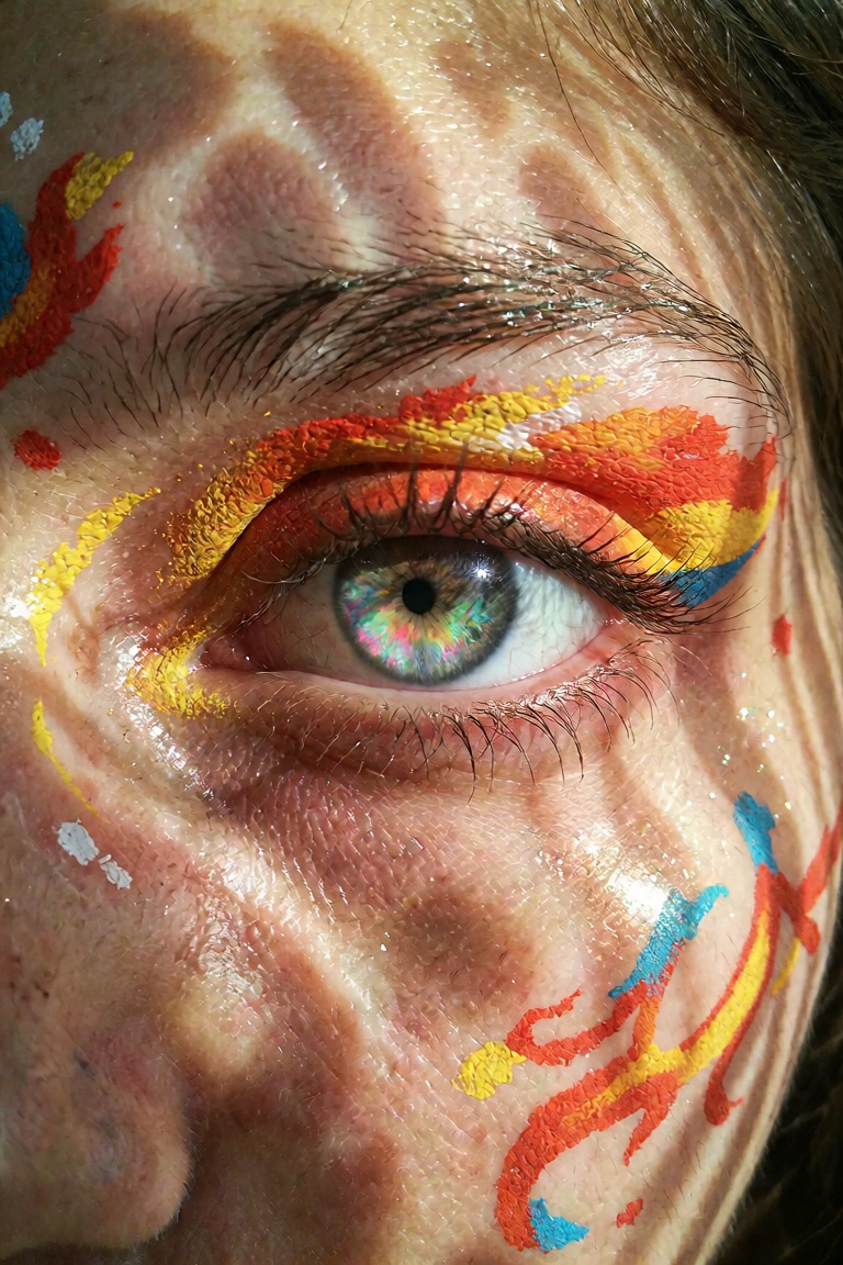 Extreme close-up macro portrait of a person's face,  focusing on a mesmerizing iridescent eye with multi-colored swirling...