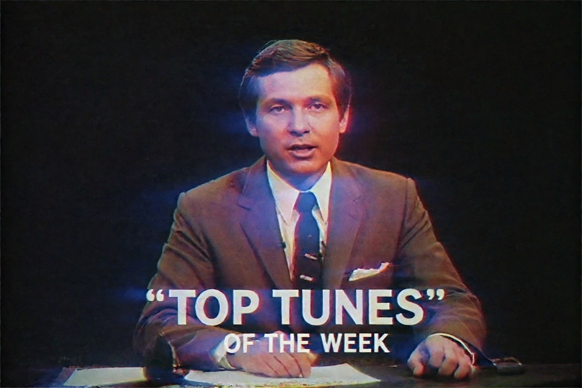 a vintage broadcast host in a suit and tie presents "Top Tunes of the Week,  " the entire dark scene defined by extreme ch...