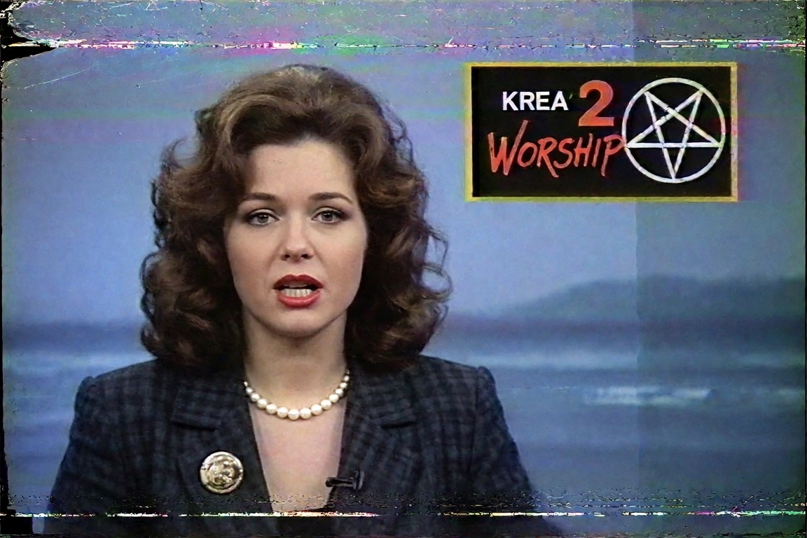 A 1980s local-TV news broadcast captured off a worn VHS tape. A female news anchor with a big teased curly brown hairstyle...