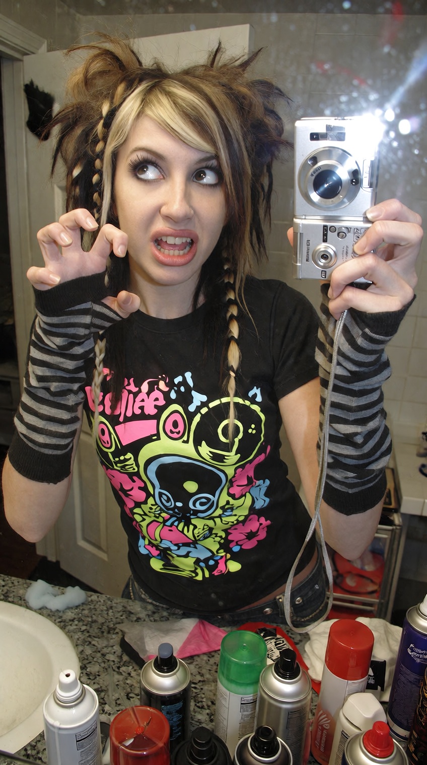 @2000s_core,  A high-angle mirror selfie taken by a girl with teased,  choppy "scene" hair featuring blonde and black "coo...