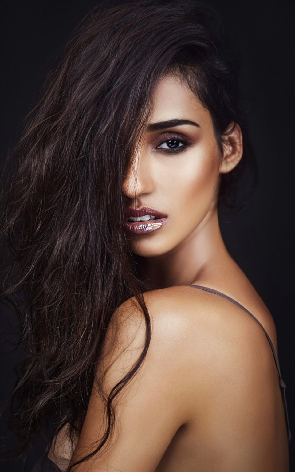 A close-up head-and-shoulders portrait of a sultry woman,  her face turned slightly to the left,  gazing directly at the v...