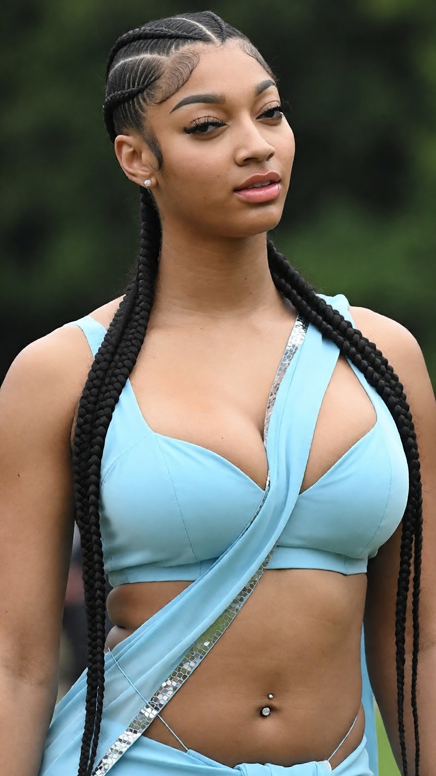Photograph of a black woman with a light brown skin tone and long,  intricately braided black hair styled in tight cornrow...