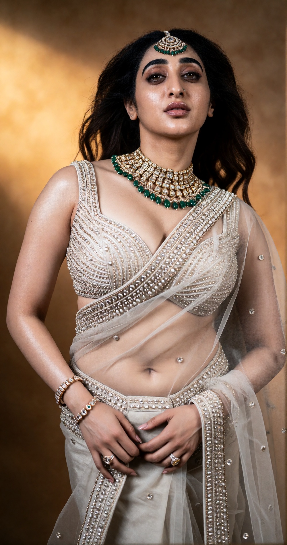 Photograph of a young woman with long,  wavy brown hair,  wearing a traditional Indian bridal outfit. She has a light to m...