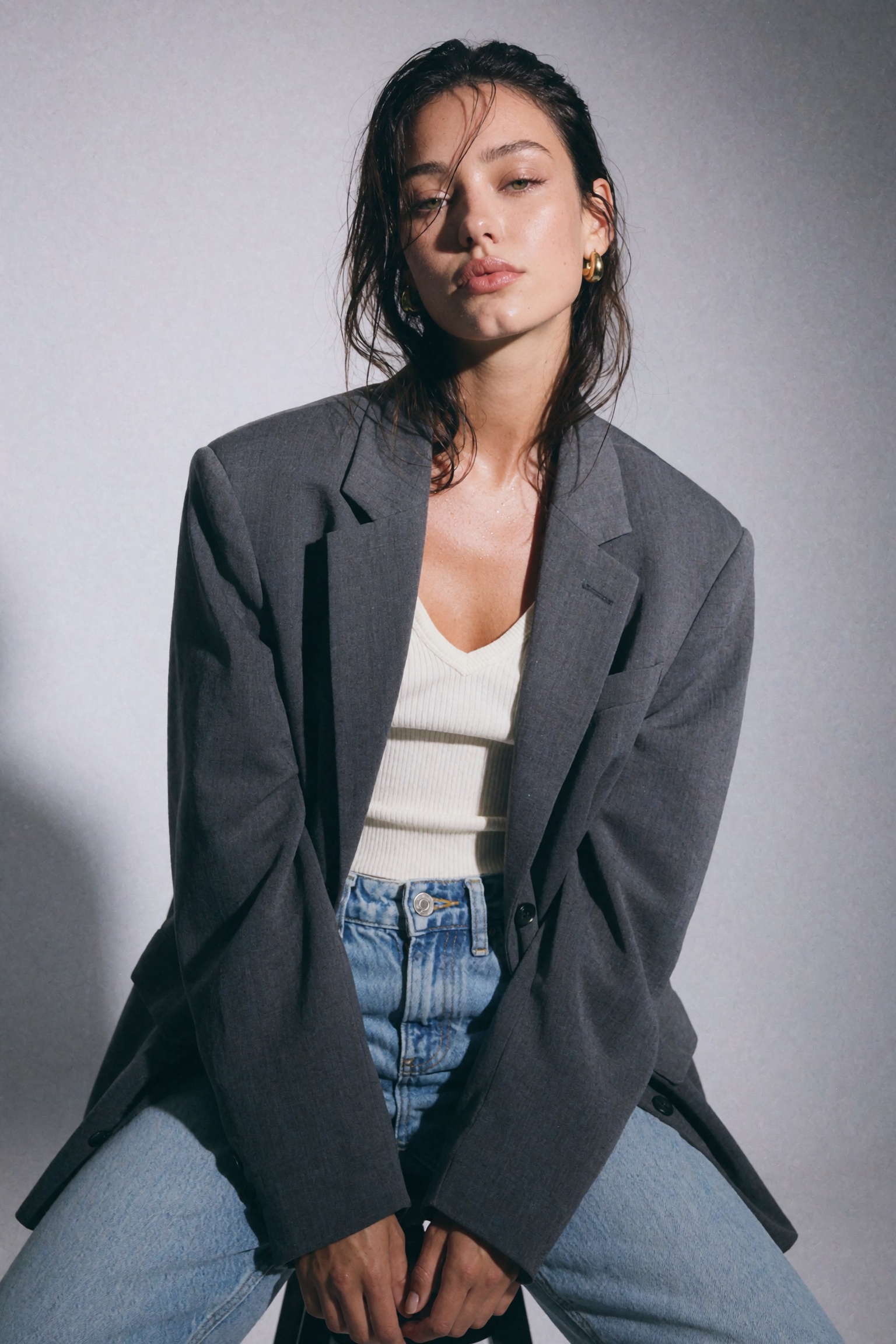 Candid documentary-style UGC smartphone studio snapshot of a young woman seated,  leaning slightly forward,  head tilted b...