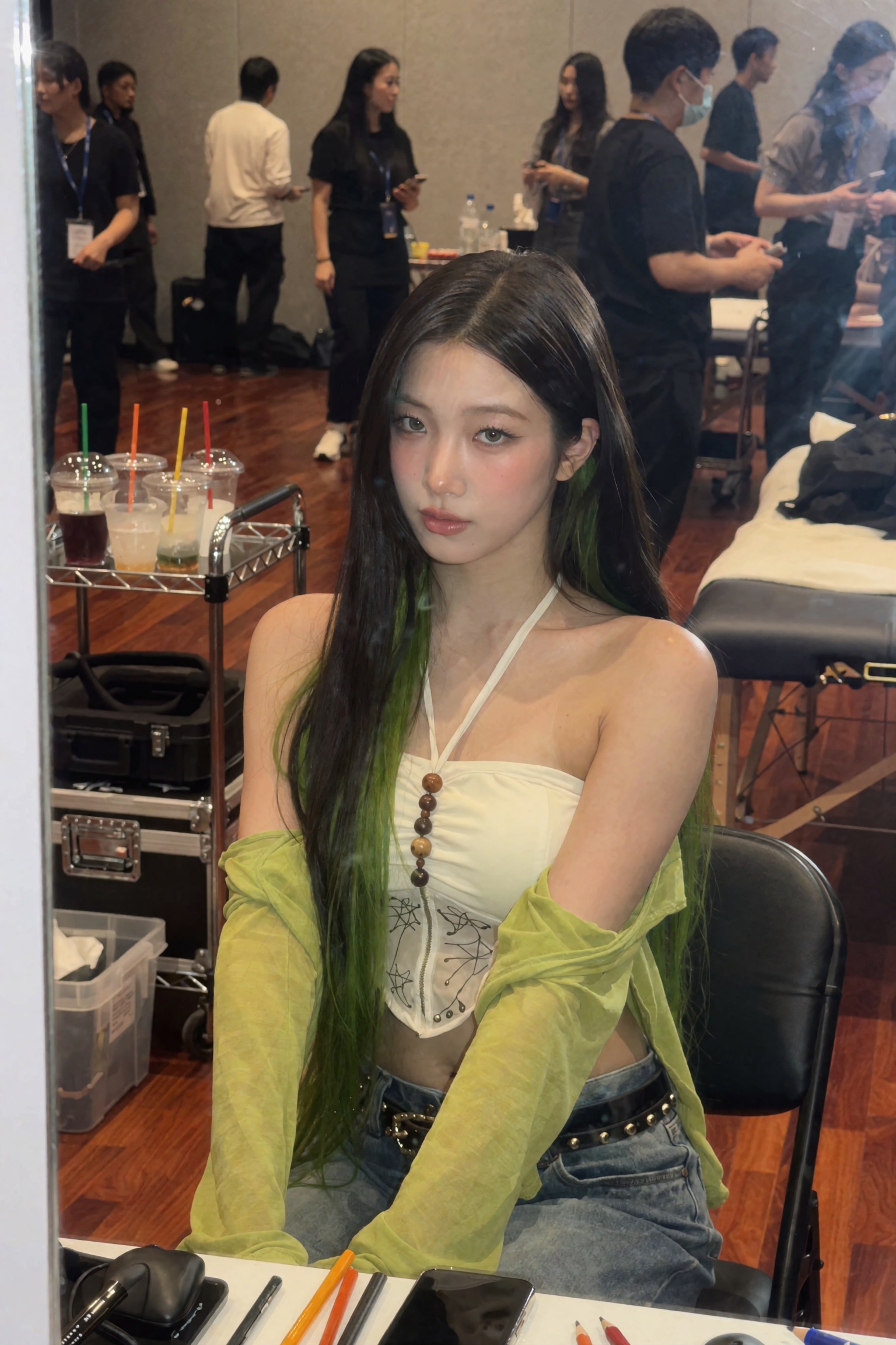 Candid UGC smartphone backstage mirror snapshot of a young woman seated in a dressing room,  body angled three-quarter,  g...