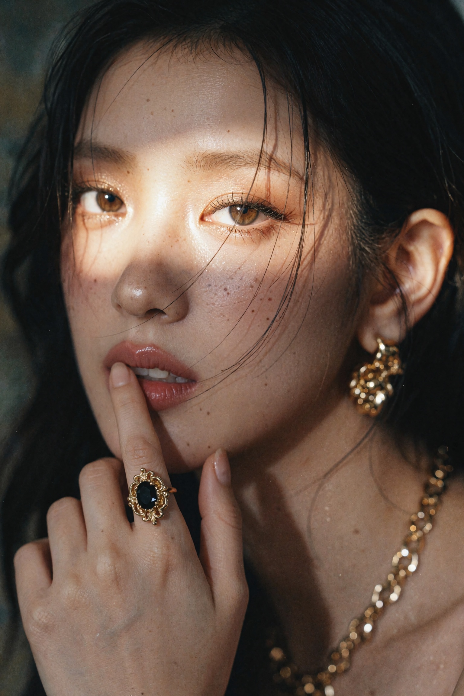 An extreme close-up beauty portrait of a young woman with dark hair and luminous hazel-brown eyes,  a diagonal band of war...