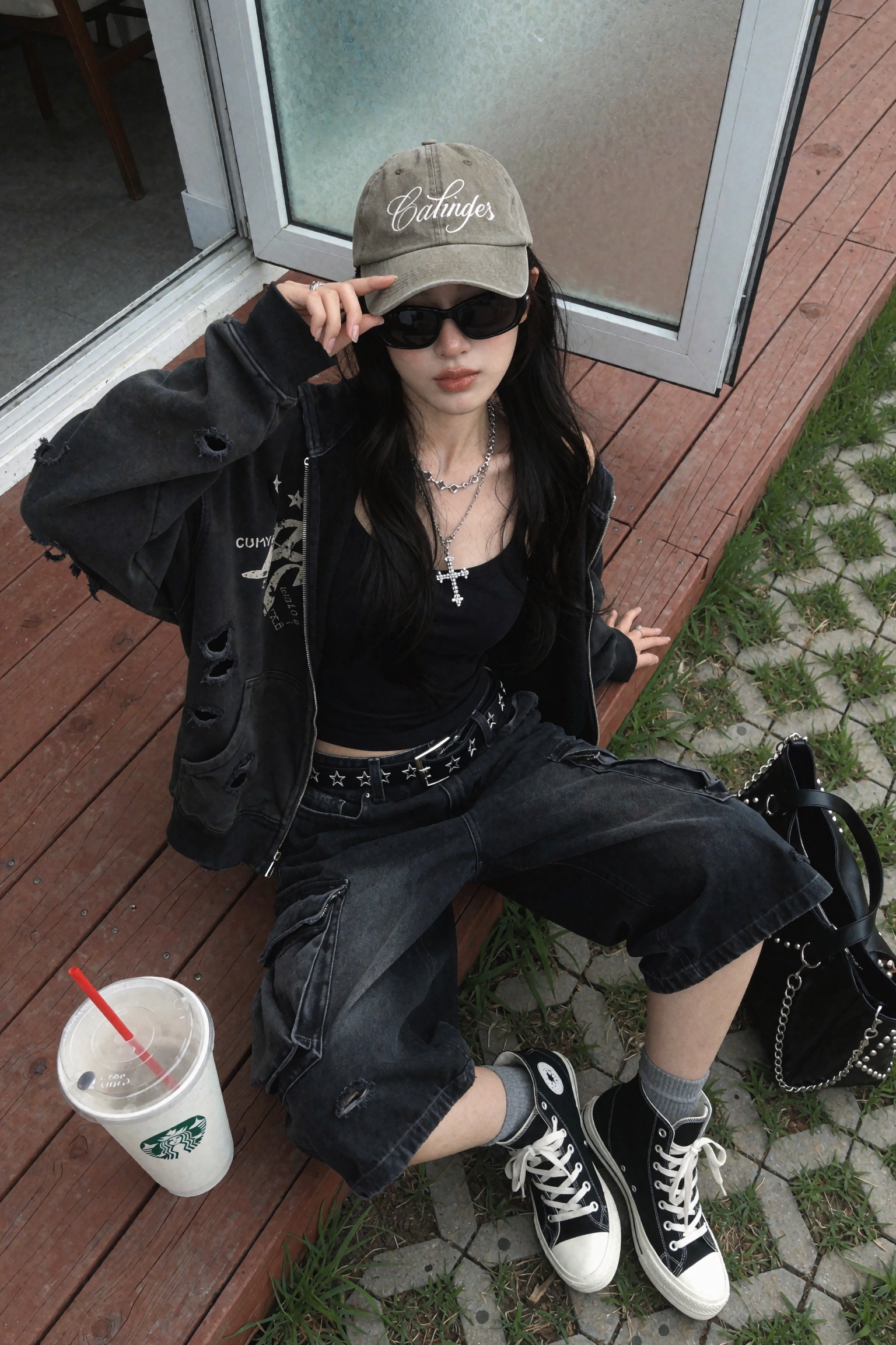 Candid UGC smartphone streetwear OOTD snapshot of a young woman seated on a reddish-brown wooden deck,  shot from a high o...