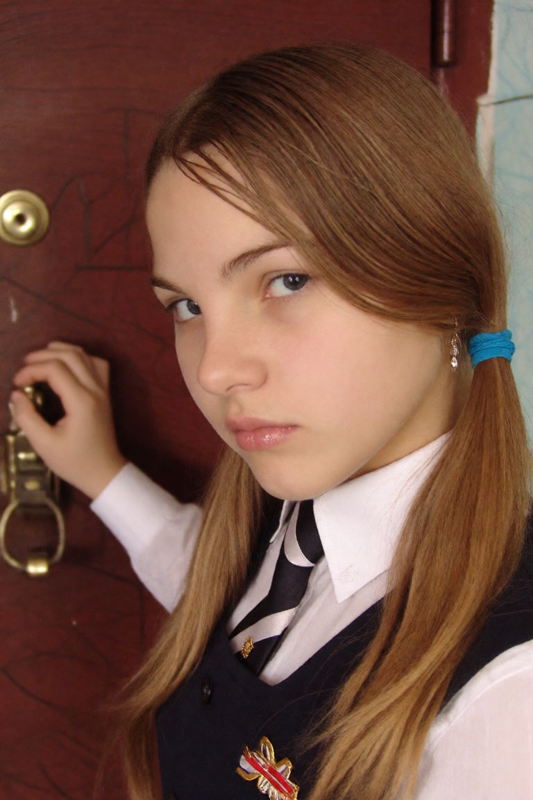 candid close up photo of a girl wearing a soviet school uniform,  she is standing beside her apartment frontdoor on Tensor...