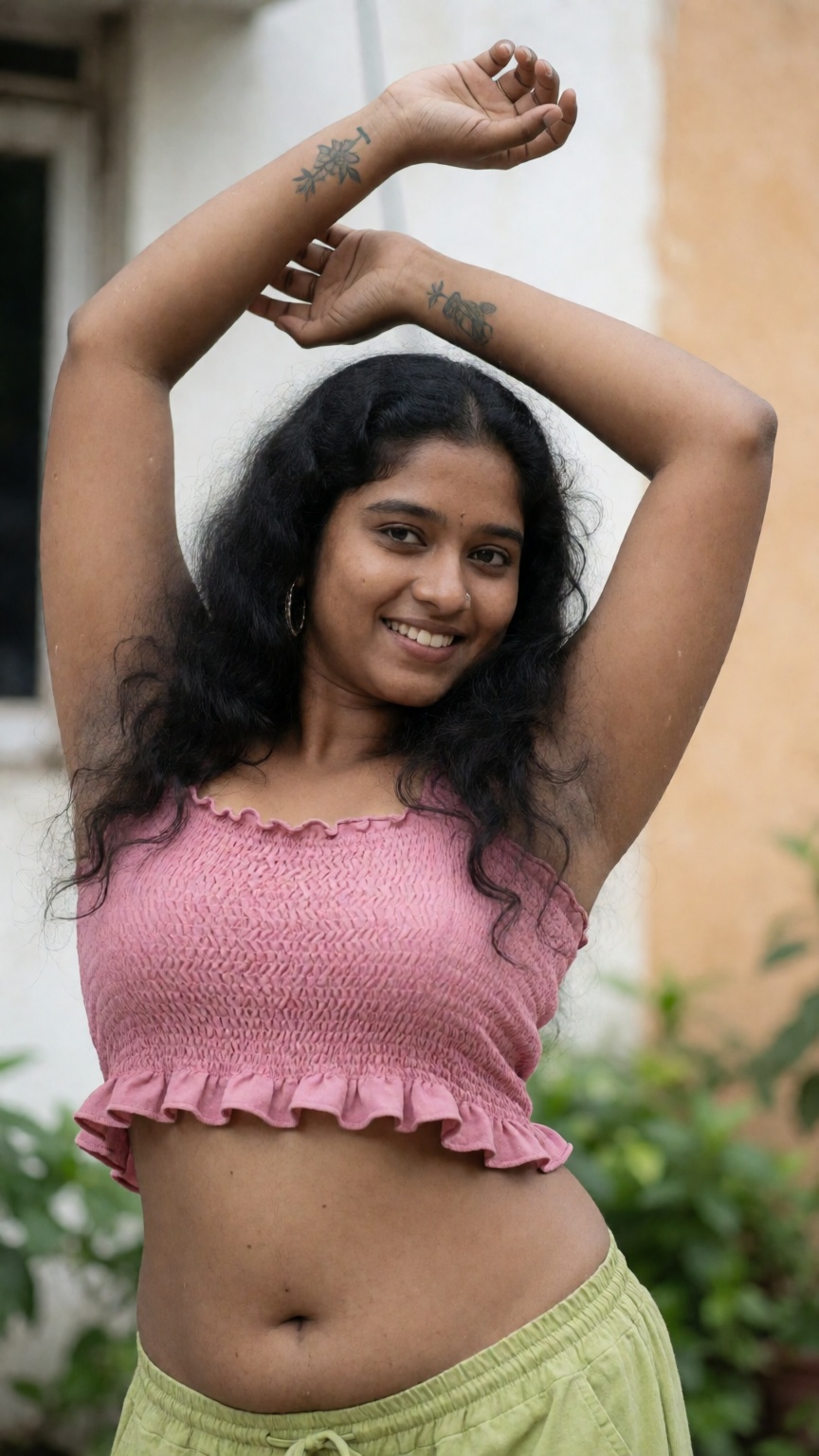 Photograph of a smiling young woman with medium brown skin and long,  wavy black hair. She is wearing a pink,  sleeveless...