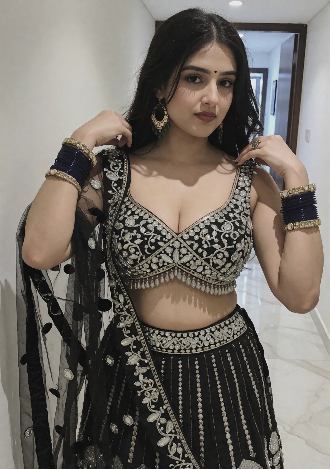 The image shows a south asian indian woman wearing a ethnic black lehenga outfit adorned with intricate silver embellishme...