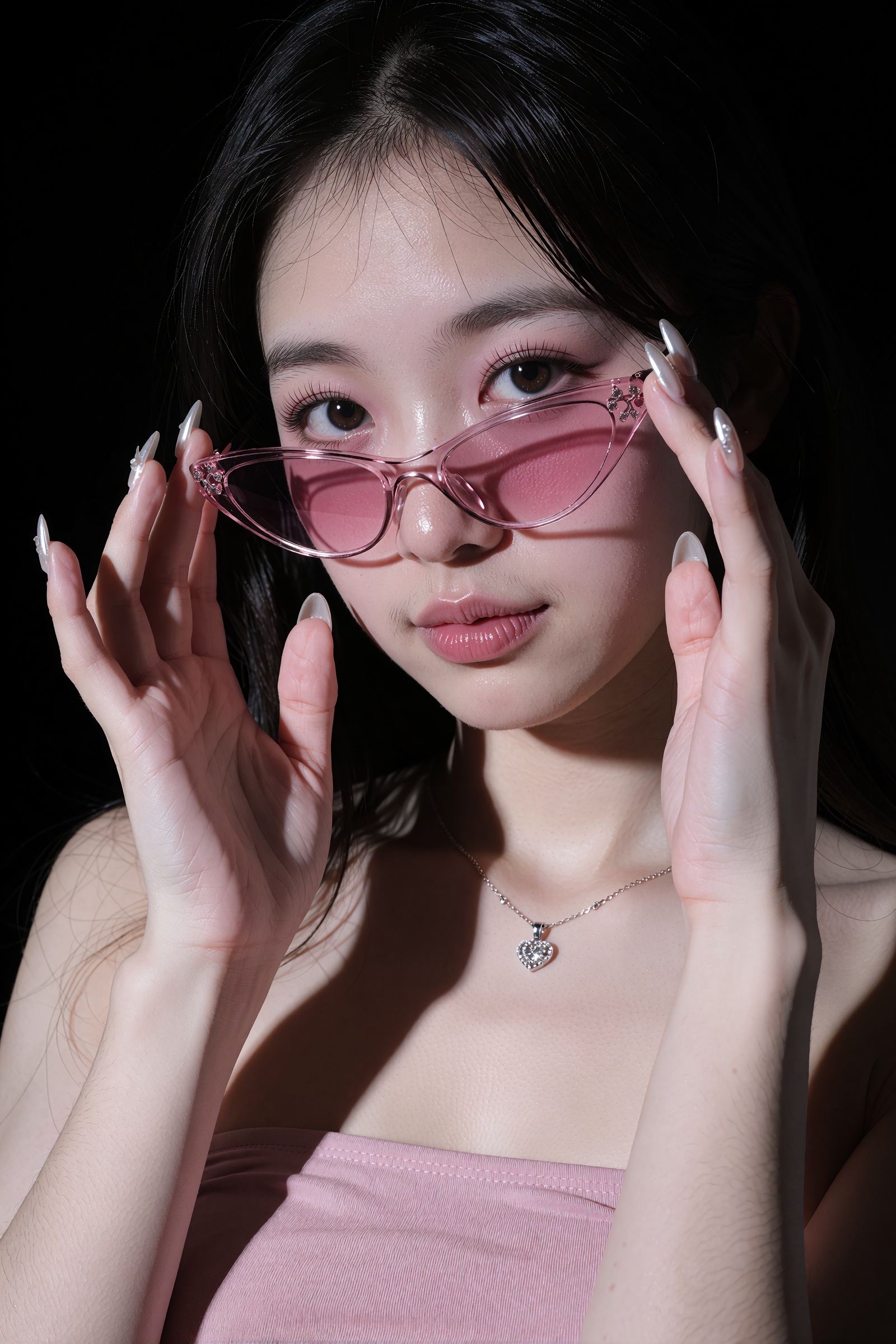 A close-up portrait of a young East Asian woman adjusting pink cat-eye sunglasses against a solid black background. She we...