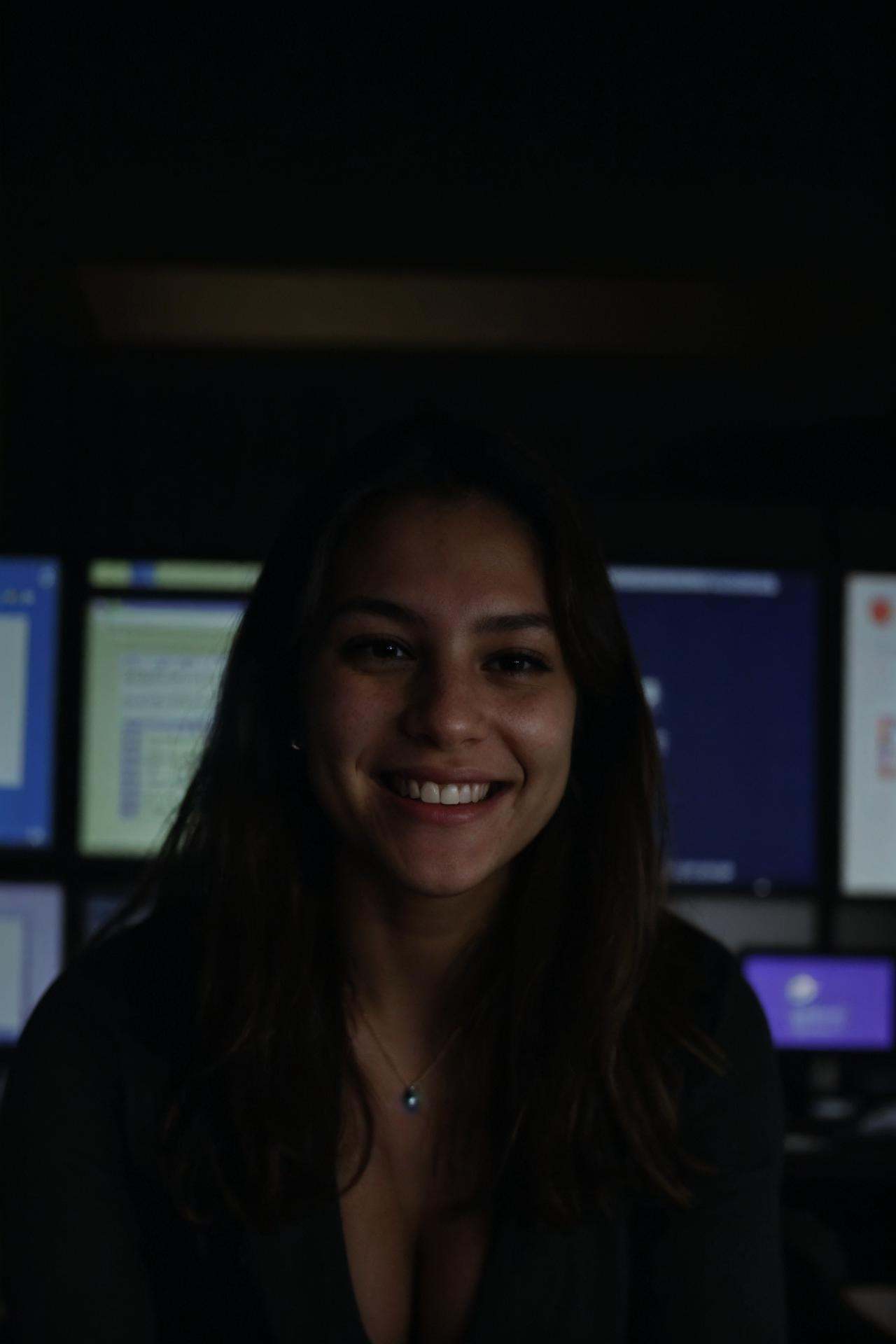 A female social worker having fun in a dark room surrounded by computer screens,  poor quality photo,  blurry on Tensor.Art