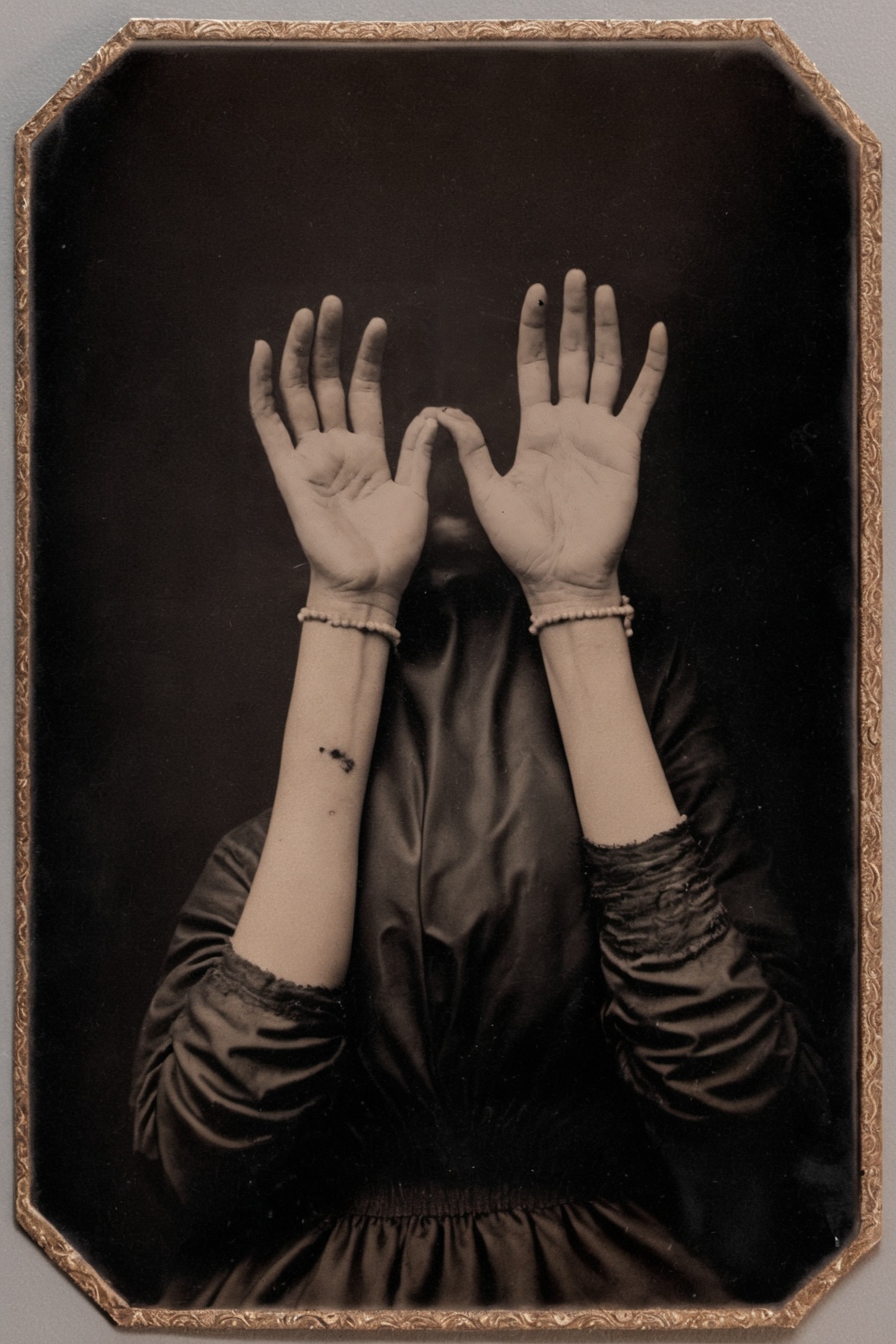 hyperrealistic tintype photo of a woman's hands,  palms facing up,  holding a small pile of sparking black sand on Tensor.Art