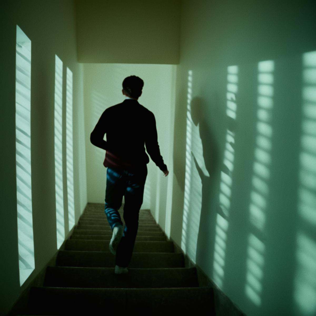 cinematic film still of A cucoloris patterned illumination casting a vertical window shadow on a person running down a set...