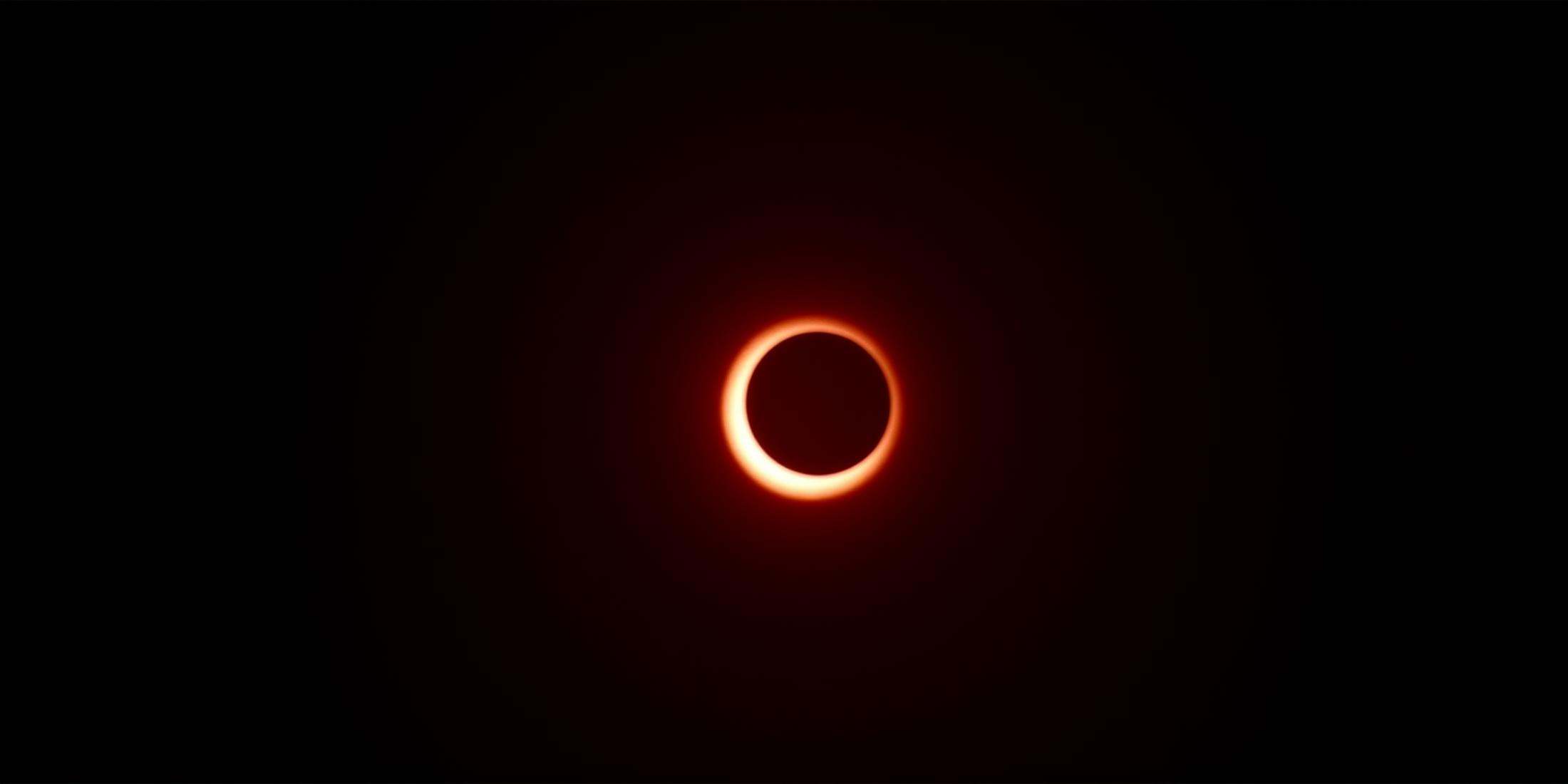 cinematic film still In RonFricke cinematic film style a partial eclipse of the sun in the dark,  glowing,  black backgrou...