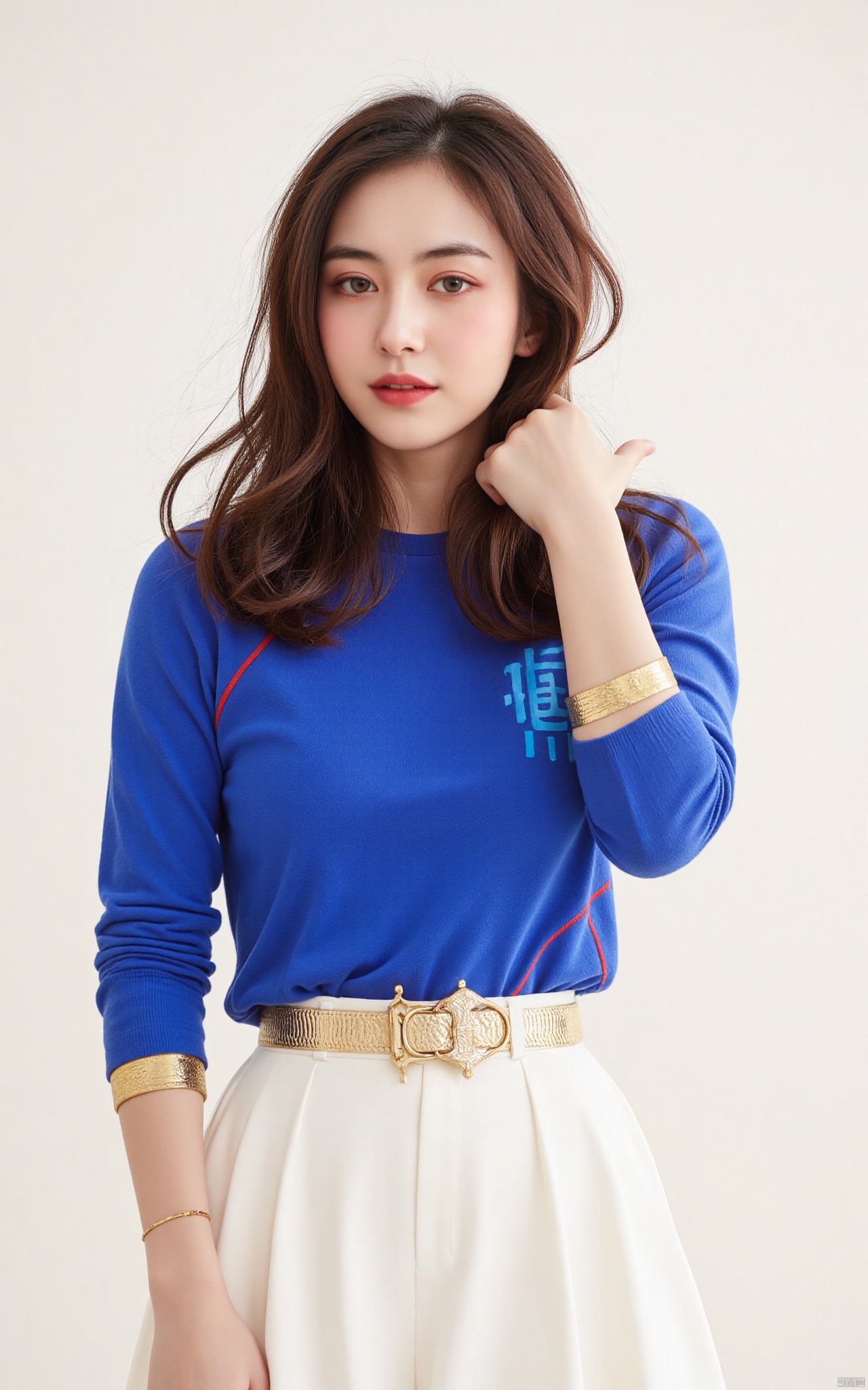 Captured in a low-angle shot, a woman dressed in a white skirt, adorned with a gold belt, stands in front of a stark white wall. The woman's hair is long and cascades down her shoulders, adding a touch of warmth to her outfit. Her eyes are a piercing blue, while her lips are a darker shade of brown. She has long brown hair, and her bangs are pulled back. She is wearing a blue long-sleeved shirt with a red stripe down the left side of her chest. The shirt is adorned with the letter "S" in blue, and the sleeves are adorned with gold bands. She stands with her left hand on her hip. Her left hand is draped over her right shoulder. Her right hand is positioned on her left wrist. Her hair is pulled back in a ponytail, and she has a slight smile on her face.