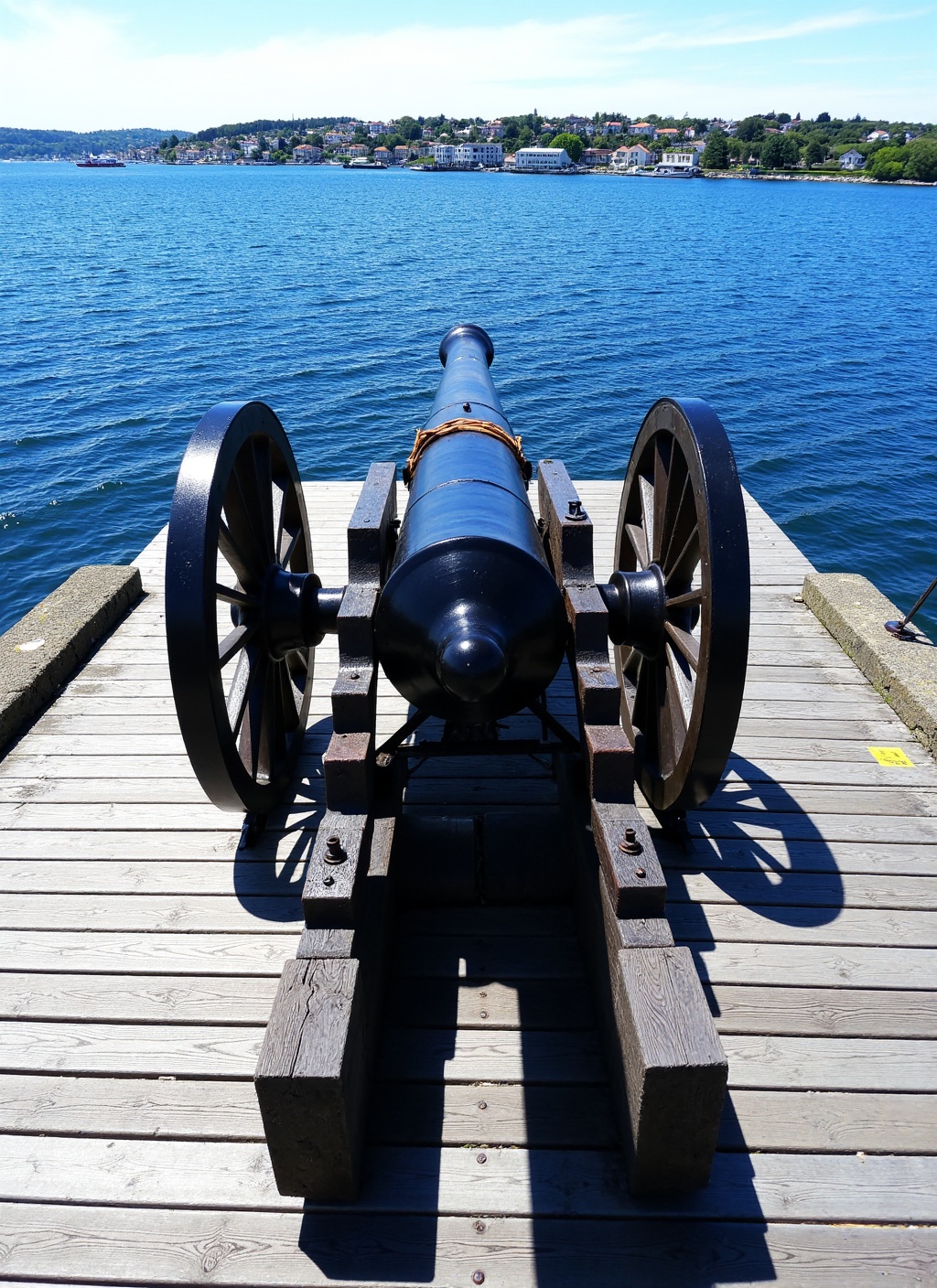 The image presents a striking,  eye-level perspective of an antique cannon positioned on a weathered wooden pier,  looking...