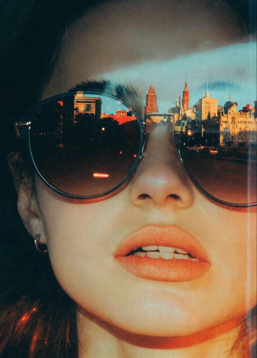 woman's face with an urban cityscape reflected in her sunglasses. The woman's skin is depicted with a smooth,  glossy text...
