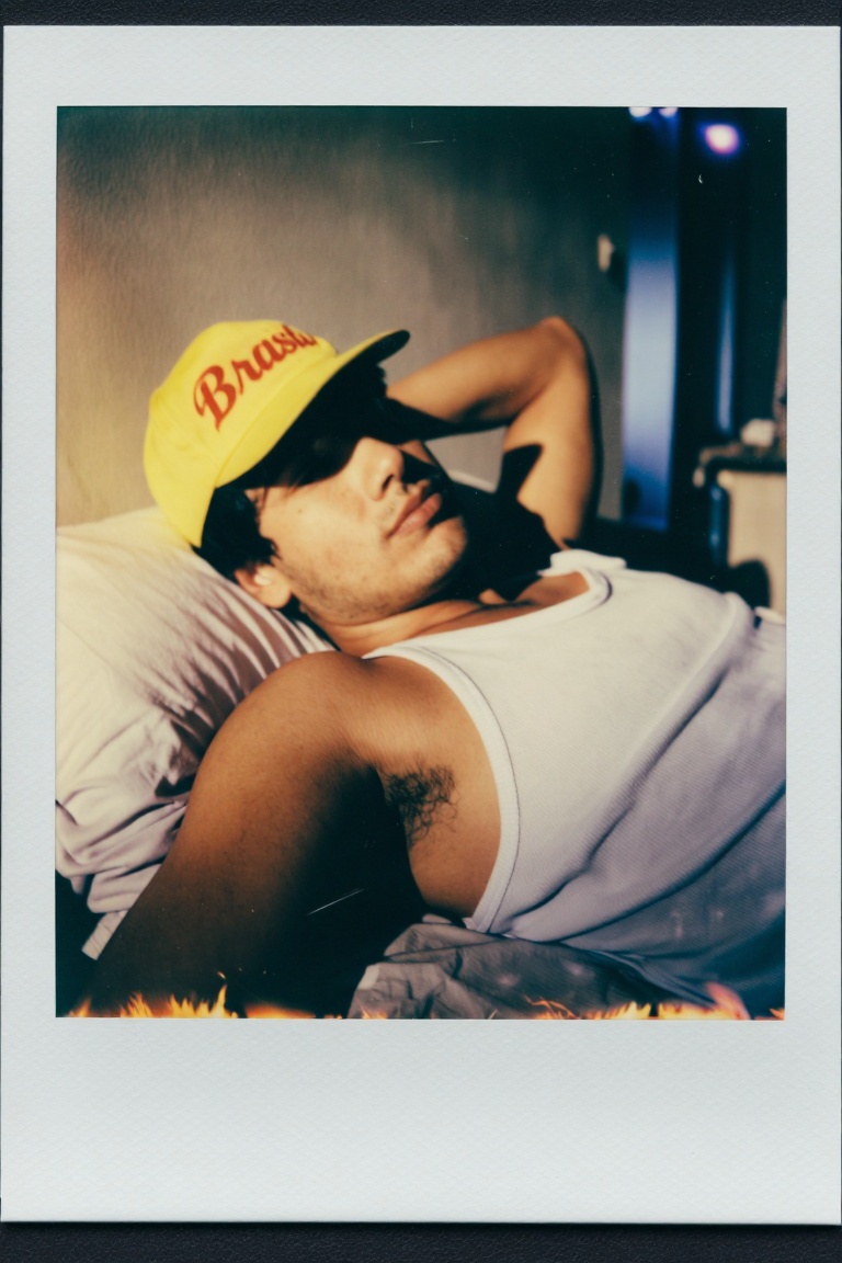 [Subject] The image shows a person wearing a yellow cap with the word "Brasil" written in red cursive. The individual is l...