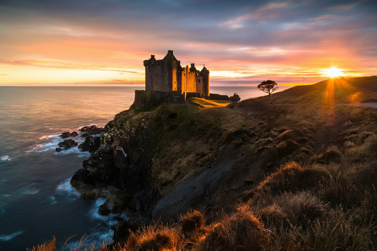aurelmanea3z photography. A breathtaking,  wide shot of an ancient Scottish medieval castle perched majestically on a deso...