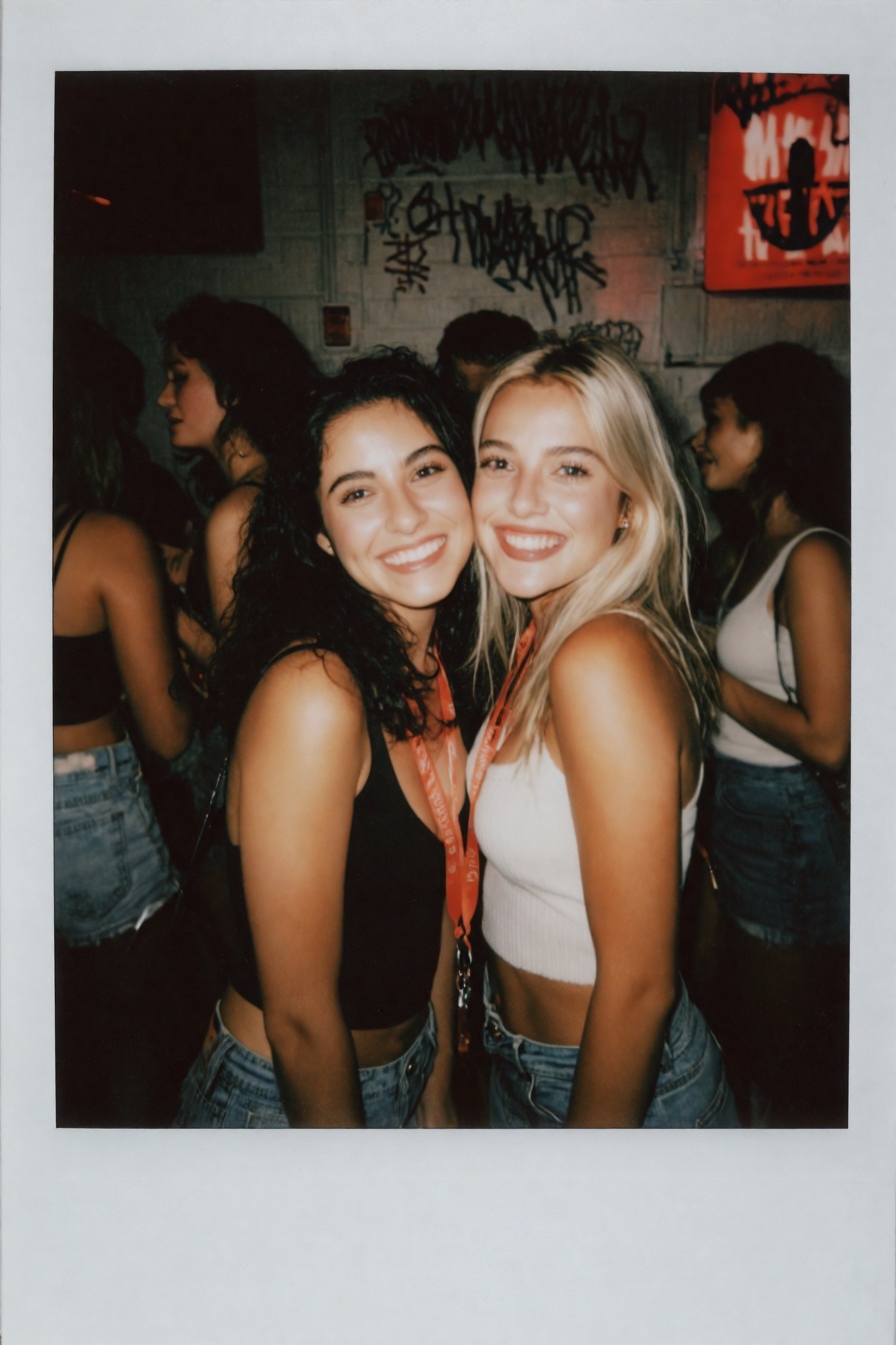 Candid Instax Photo,  The image is a polaroid photograph of two young women posing for a photo together. They are standing...