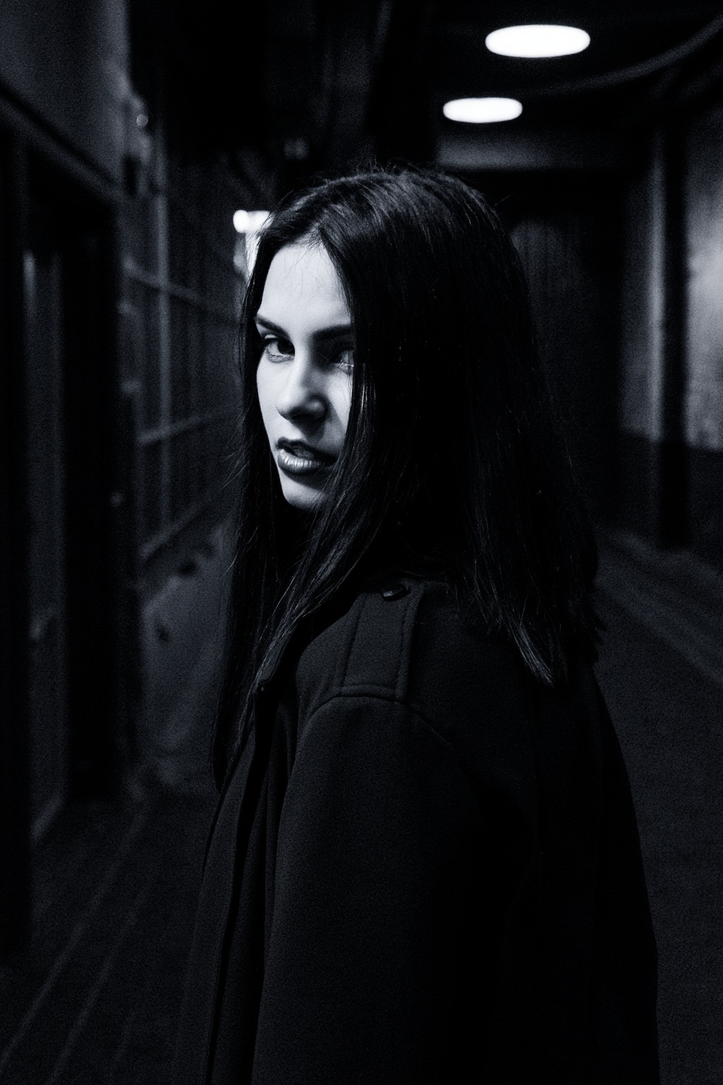 A slow,  deliberate turn of the woman's head to the left dominates the frame,  capturing a dark and mysterious atmosphere....