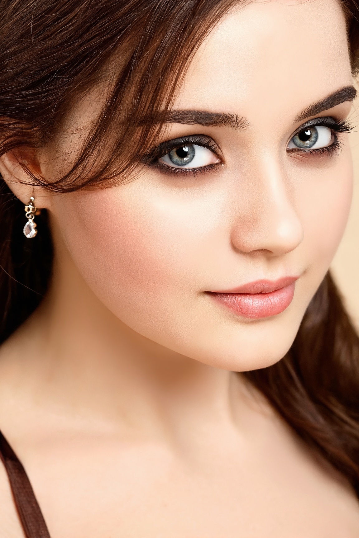 A close-up portrait of a young woman's face is angled towards the right side of the frame. The woman's eyes are a piercing...