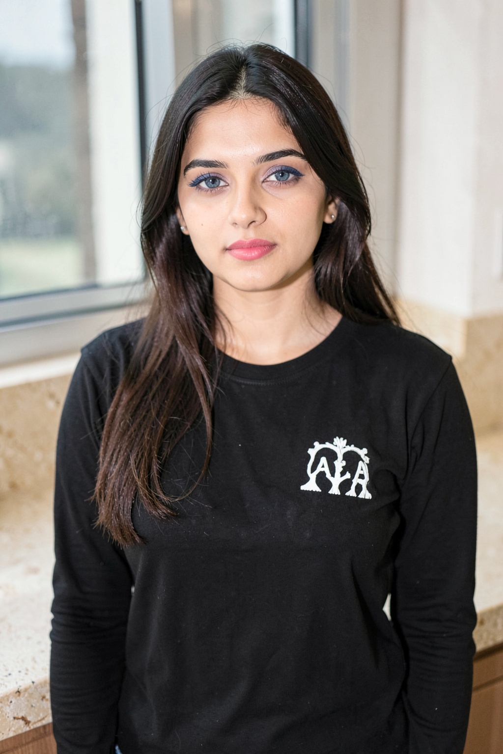 RIMP,  a medium-sized Indian_woman with long dark brown hair,  wearing a black long-sleeved t-shirt with a white logo on t...