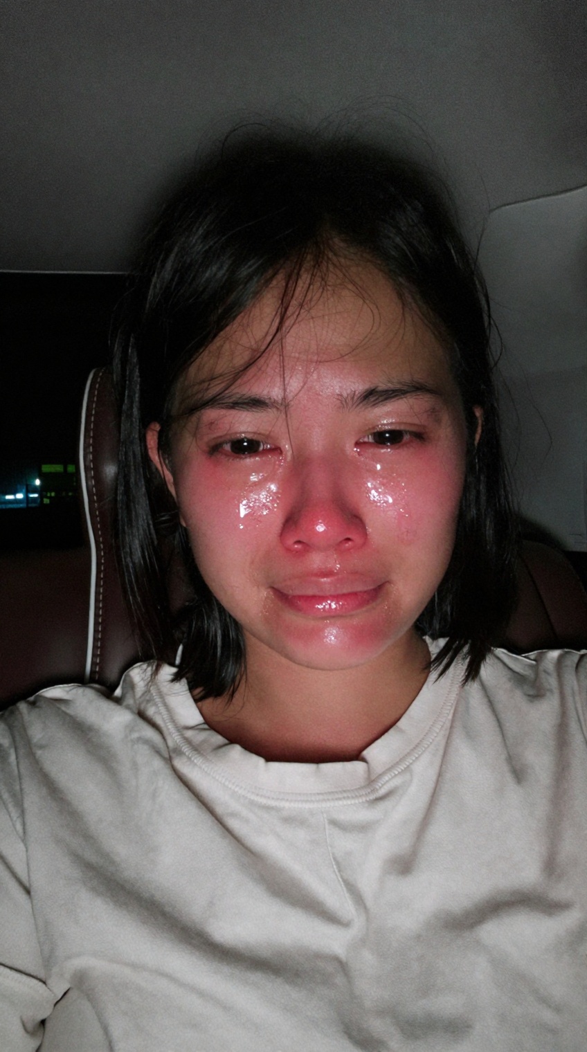 taken_by_ph0ne,  A candid,  unedited mobile phone front-camera selfie of a young Southeast Asian woman sitting inside a ca...