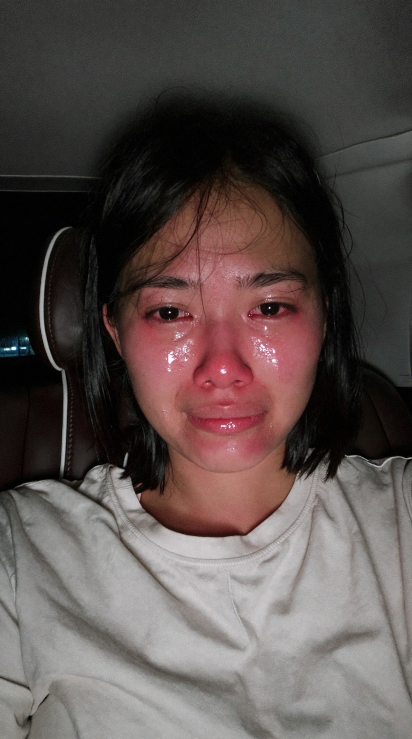 taken_by_ph0ne,  A candid,  unedited mobile phone front-camera selfie of a young Southeast Asian woman sitting inside a ca...
