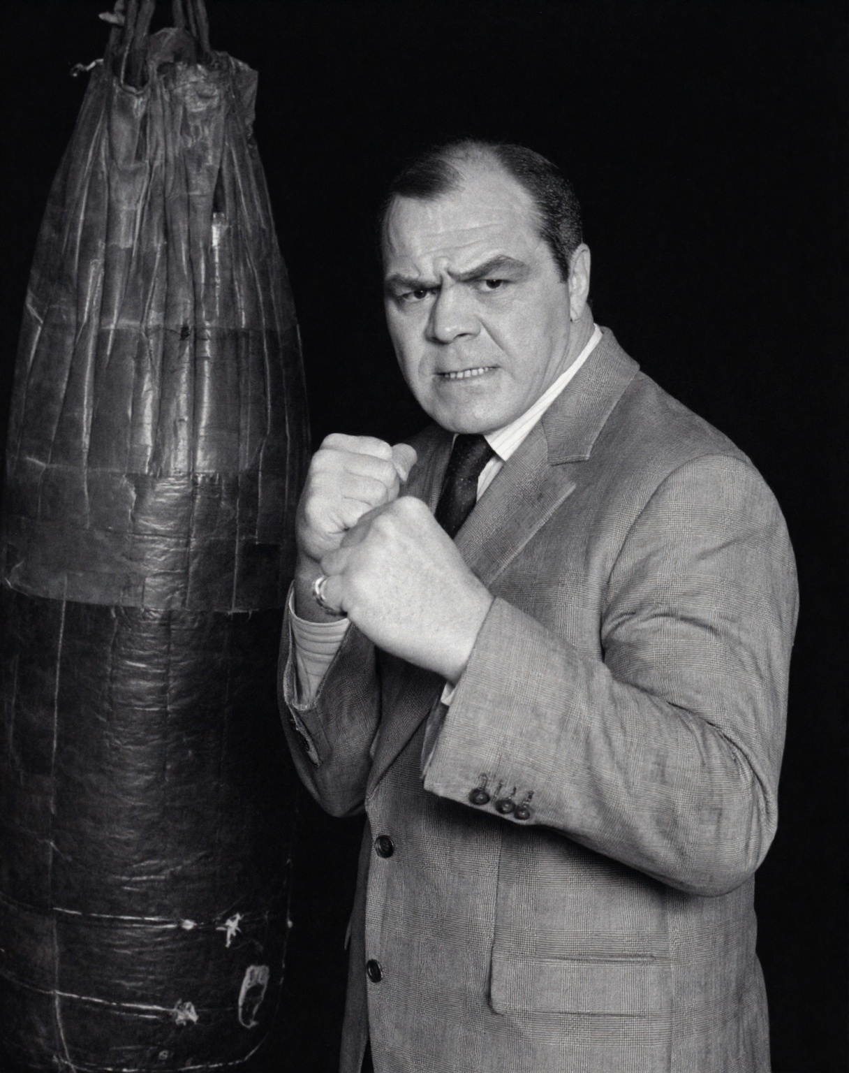 A black and white medium shot captures l3nmc1n man in a dynamic boxing pose,  his body angled slightly to the right while...